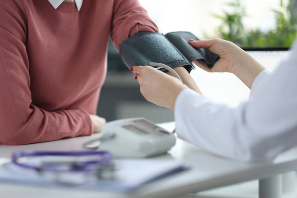 Doctor measures patients blood pressure at appointment - Fotoğraf, Görsel