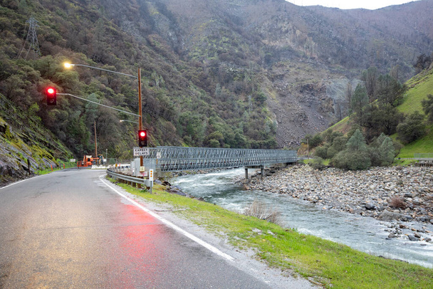 construction site at road with red traffic ligh in yosemite national park by bad weather with river bridge spanning Mariposa creek, USA - Photo, Image