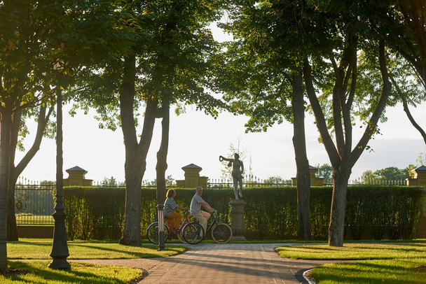 Ώριμο ζευγάρι ποδηλασία στο πάρκο της πόλης. - Φωτογραφία, εικόνα