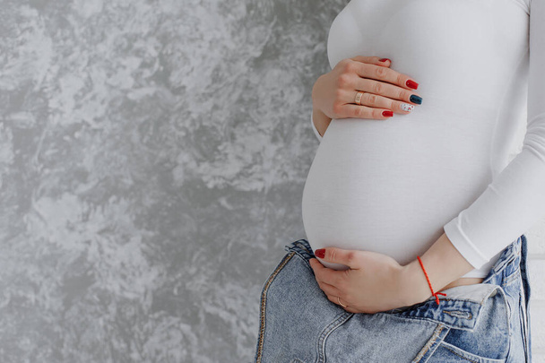 Беременная девушка обнимает живот - Фото, изображение