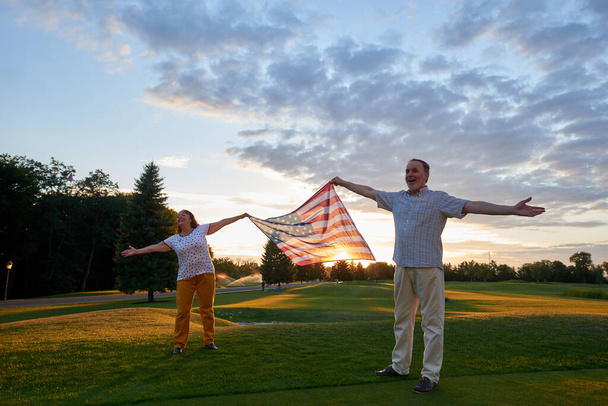 Man and woman holding usa flag outdoors. - Photo, Image
