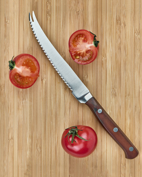 Tomato knife and tomatoes on a wooden background, flat lay - Photo, image
