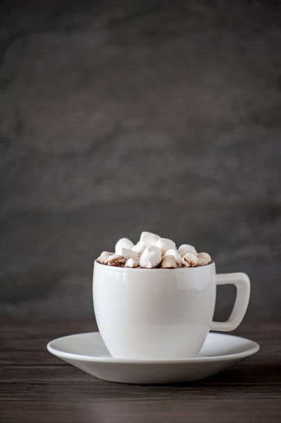 cup of coffee with a slide of marshmallows on a wooden table - Foto, immagini