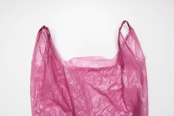 Handles of a red plastic bag on white background - Fotografie, Obrázek
