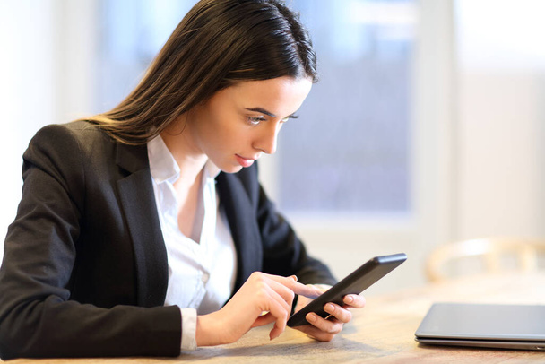 Business woman checking mobile phone working in a table at office - Foto, Bild