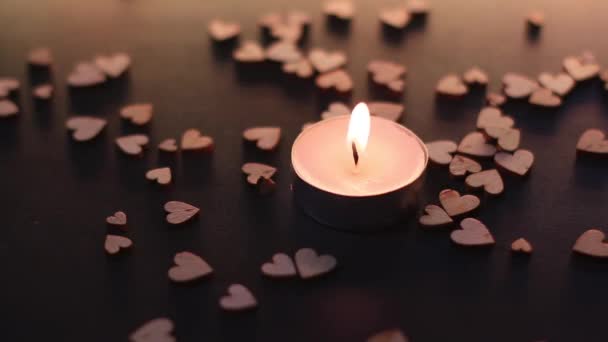 Zdmuchnij świeczkę w pobliżu drewnianych figurek w kształcie serca na biurku. dym w zwolnionym tempie. Walentynki, Walentynki, miłość, związek, romantyczne. Wysokiej jakości materiał filmowy FullHD - Materiał filmowy, wideo