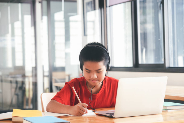 Χαρούμενο παιδί ενθουσιασμένο με τη χρήση υπολογιστή για online εκμάθηση. Online εκπαίδευση και αυτο-μελέτη και κατ 'οίκον διδασκαλία έννοια. - Φωτογραφία, εικόνα