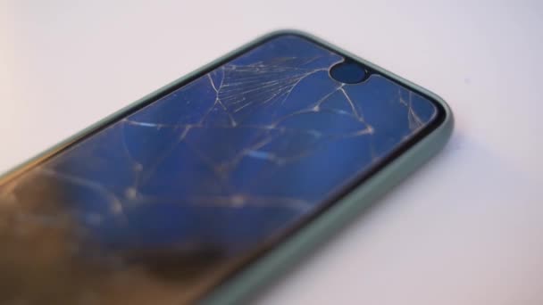 携帯電話はテーブルの上にある。壊れた画面でスマートフォン、ガラス。画面の修復、ガラスの交換、修正. - 映像、動画