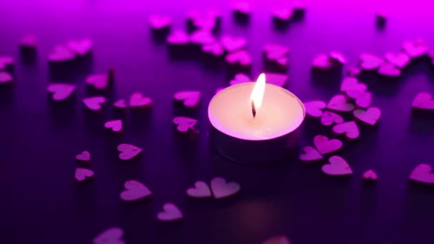 apague uma vela perto de figuras em forma de coração de madeira na mesa na luz de fundo rosa. fumar em câmara lenta. São Valentim, Dia dos Namorados, amor, relacionamento, romântico. Imagens FullHD de alta qualidade - Filmagem, Vídeo