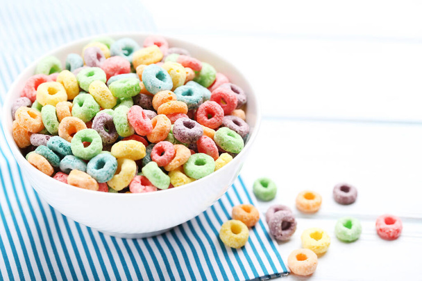 Colorful corn rings in bowl on white wooden table - Photo, Image