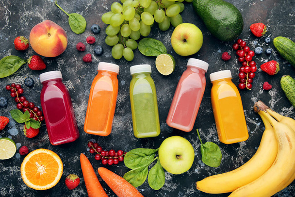 Smoothie in plastic bottles with fruits and vegetables on wooden background - Zdjęcie, obraz