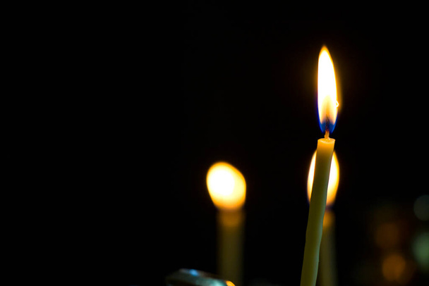 Świeca do modlitwy w kościele, jasne i ciemne tło, duża grupa świec - Zdjęcie, obraz