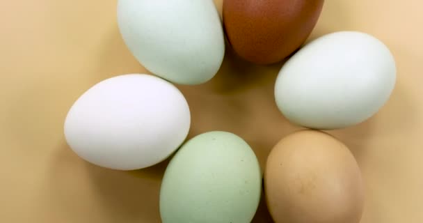 Naturalnie barwione jaja obracające się na beżowym tle. - Materiał filmowy, wideo