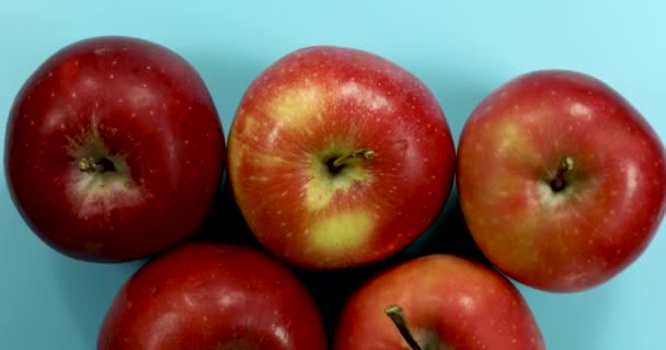 Rote Äpfel auf hellblauem Hintergrund, vereinzelte Früchte 4k.  - Filmmaterial, Video
