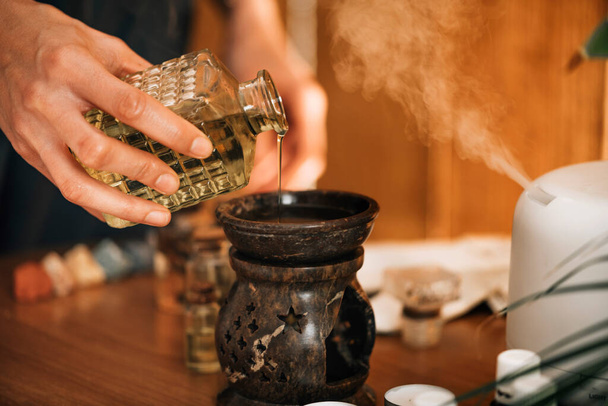 Ayurveda aromaterápiás masszázs, női kéz öntő aromás olaj illóolaj diffúzor - Fotó, kép