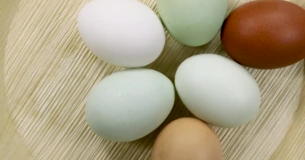 Natuurlijk gekleurde eieren draaiend op een houten plaat. - Video