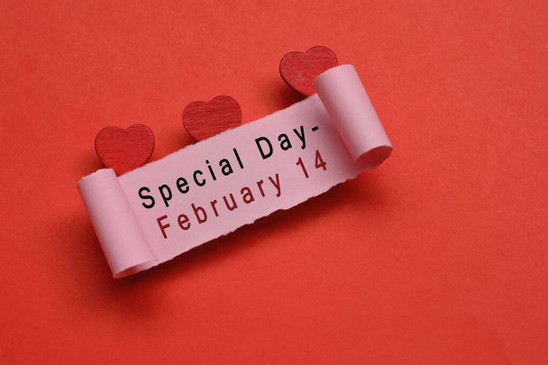 Speciální den 14. února štítek na roztrhaném papíru s červeným papírovým pozadím. Valentýn a koncepce výročí svatby - Fotografie, Obrázek