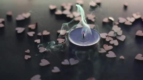 sfoukni svíčku poblíž dřevěných postav ve tvaru srdce na stole. kouř ve zpomaleném filmu. Valentýn, Valentýn, láska, vztah, romantika. Vysoce kvalitní FullHD záběry - Záběry, video