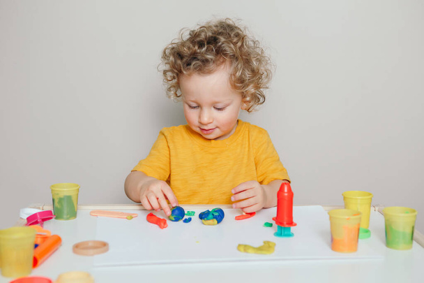 lindo caucásico rubio rizado bebé niño jugando con sensor cinético juguete playtough. Actividad de desarrollo cerebral manual para niños pequeños. Educación preescolar de edad temprana. - Foto, Imagen