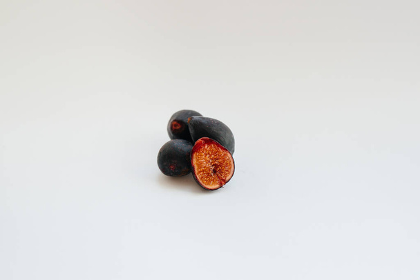 Ripe and sweet figs cut and arranged in a plate on a white background with free space. Fruits and vegetarianism - Foto, Imagem