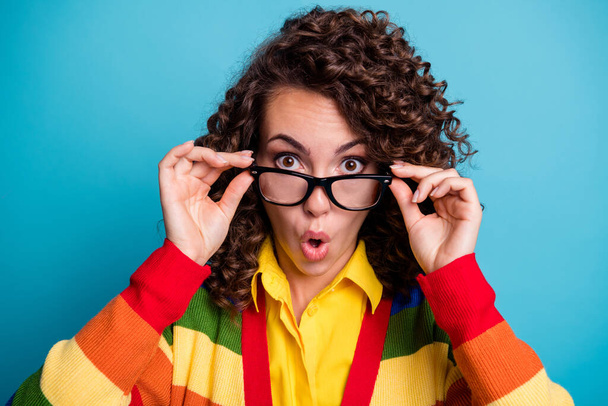 Close-up portrait of pretty amazed wavy-haired girl touching specs pout lips news reaction isolated over bright blue color background - Foto, Imagem