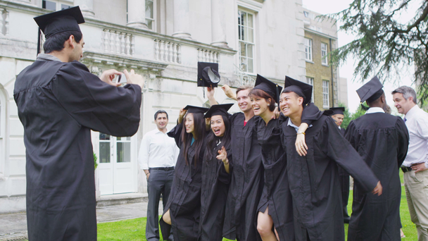 Amigos estudiantes tomando fotos el día de la graduación
 - Imágenes, Vídeo