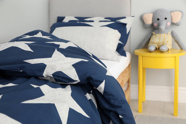 Bed with star patterned linens in child's bedroom. Interior design - Foto, Imagem