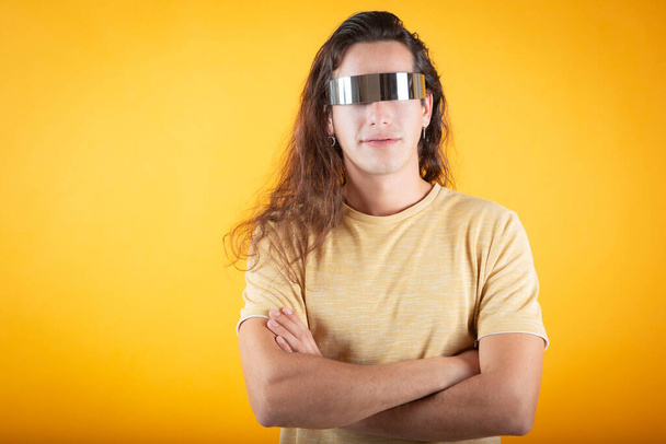 mladý muž s dlouhými vlasy a slunečními brýlemi, na žlutém pozadí, kopírovat prostor - Fotografie, Obrázek