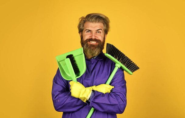 Cleaning day. Cleaning agency. Worker with brush. Cleaning equipment. Yardman occupation. Garbage removal. Janitor professional. Bearded hipster blue uniform with broom. Gardener cleaning service man - Фото, изображение