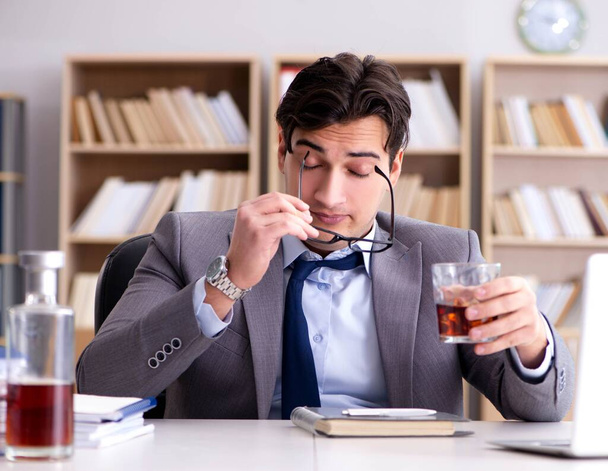 Joven hombre de negocios bebiendo del estrés - Foto, imagen