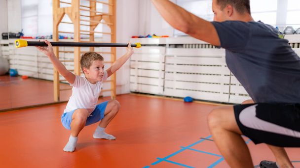 Squats with a bar, strength training and exercise for children - Photo, Image