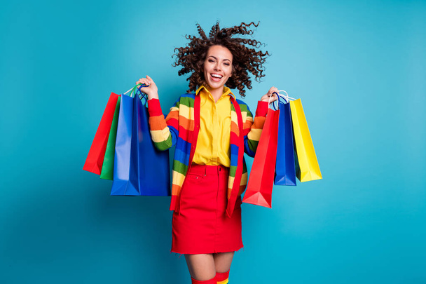 Photo of beautiful brown curly haired woman wear red skirt raise bags isolated on blue color background - Valokuva, kuva