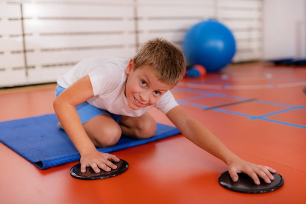 Children training with exercise gliders, improving balance and coordination skills - Valokuva, kuva