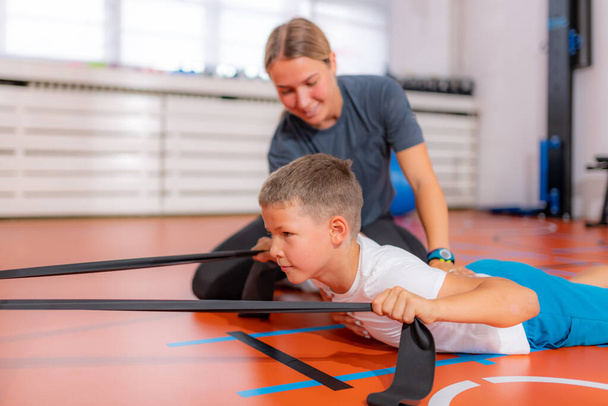 Άσκηση πλάτης για παιδιά, χρησιμοποιώντας ζώνες αντίστασης - Φωτογραφία, εικόνα