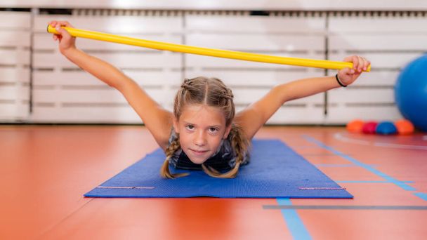 Back strengthening exercise for children with a bar - Photo, Image