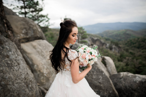 Portrait of stunning bride with long hair posing with great bouquet - Foto, Imagem