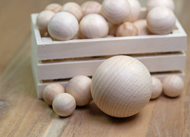 Many wooden balls in a wooden box - 写真・画像