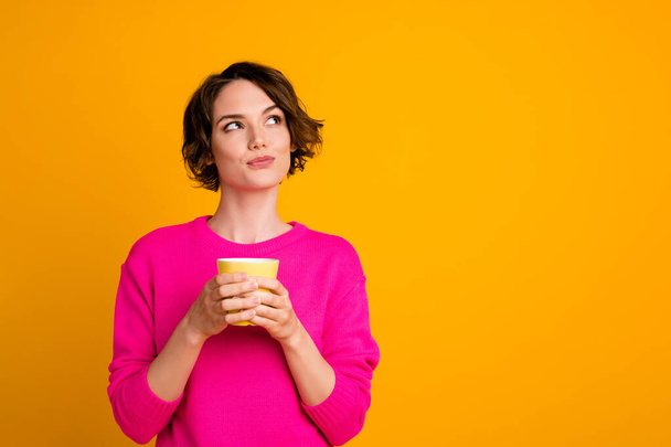 Photo of minded girl hold beverage mug look copyspace think wear pullover isolated bright shine color background - 写真・画像