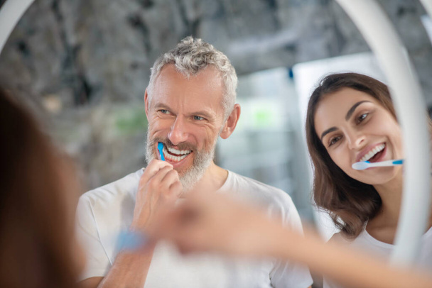 Man and woman enjoying brushing their teeth together - Foto, imagen