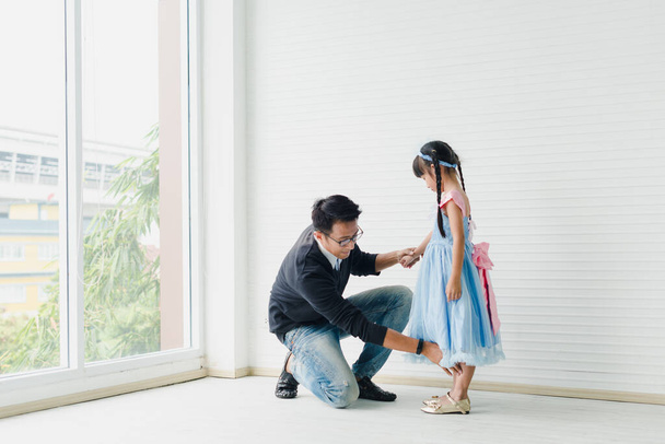 An Asian father and daughter are dancing, dad teaches daughters to dance in a fun room. - Fotó, kép
