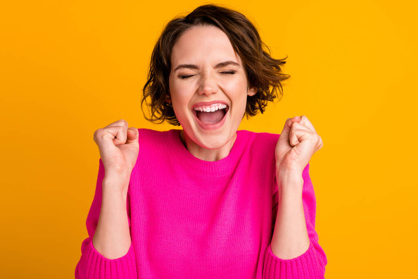 Portrait of delighted girl scream raise fists wear pullover isolated over bright color background - Foto, imagen