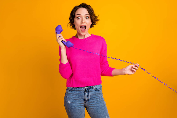 Photo of astonished girl call telephone listen information wear jumper denim isolated shine color background - Фото, изображение
