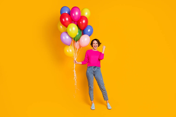 Full size photo of ecstatic girl hold balloons win raise fists wear pullover isolated bright color background - Fotó, kép