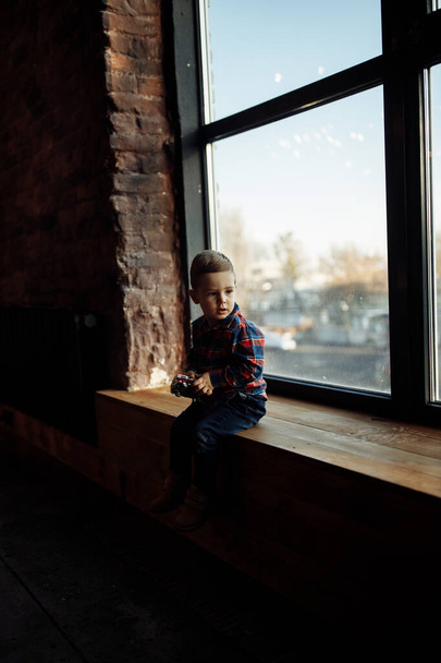 cute little boy sitting on the windowsill  - Fotografie, Obrázek
