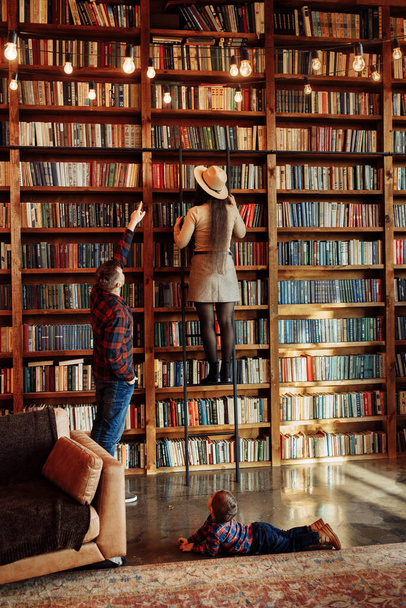 Happy young couple in the library at home - Foto, Imagen