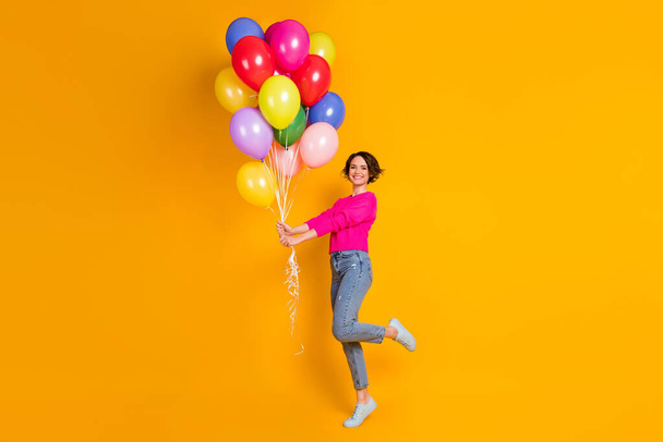 Full size photo of candid girl hold many balloons wear pullover isolated over vibrant color background - Foto, Bild
