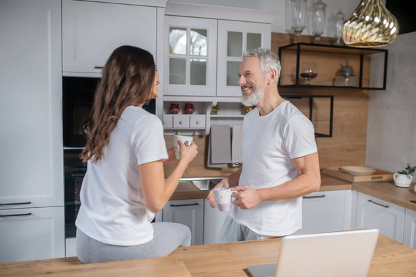 Couple having morning coffee on their kitchen - Фото, зображення