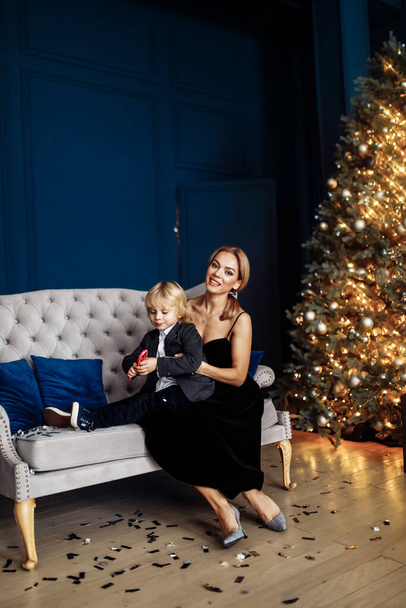 Happy young  mother and her  son  posing near Christmas tree - Foto, immagini