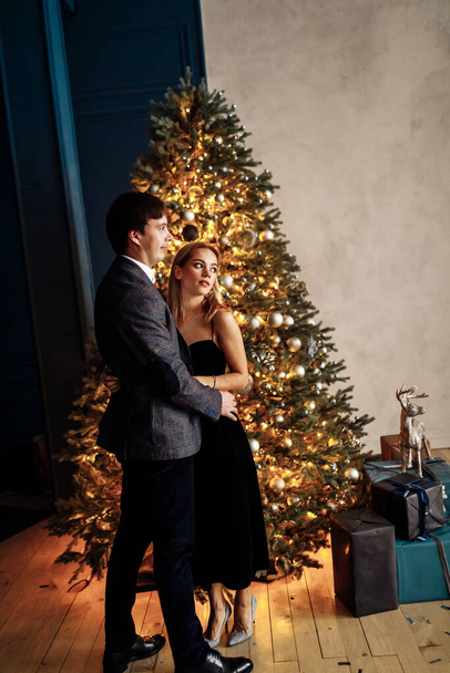 Wonderful married couple posing near Christmas tree - Zdjęcie, obraz