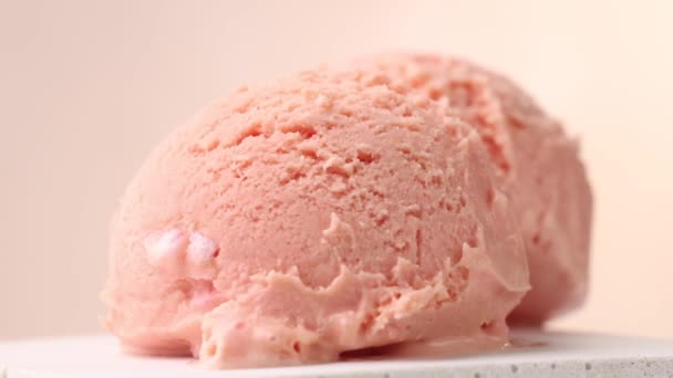 primo piano di due misurini di gelato rosa che accendono lo sfondo beige - Filmati, video